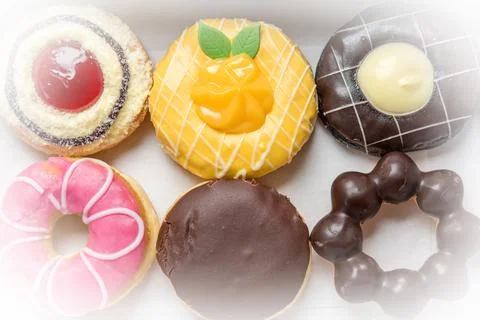 Assorted chocolate donuts coated with chocolate coated pink and sprinkled w.. Stock Photos