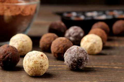 Assorted chocolates. candy balls of different types of chocolate on a brown w Stock Photos