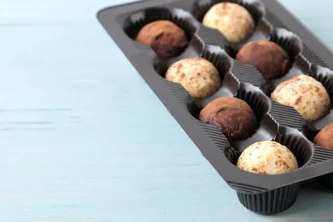 Assorted chocolates. candy balls of different types of chocolate on a blue wo Stock Photos