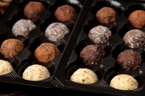 Assorted chocolates. Candy balls of different types of chocolate in a box on Stock Photos