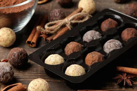 Assorted chocolates. candy balls of different types of chocolate on a brown w Stock Photos
