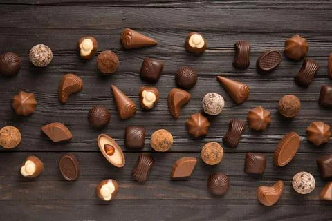 Assorted chocolates on dark wooden background top view Stock Photos