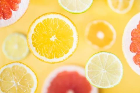 Assorted citrus sliced fruit levitating above yellow background Foto stock
