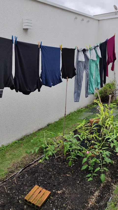 Assorted clothes hanging on a clothesline to dry in a backyard. Stock Footage 312897784