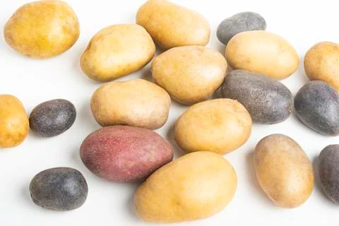Assorted Color Potatoes On White Surface Table Stock Photos