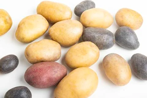 Assorted Color Potatoes On White Surface Table Stock Photos