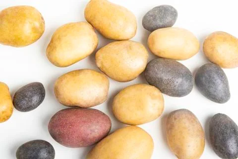 Assorted Color Potatoes On White Surface Table Stock Photos