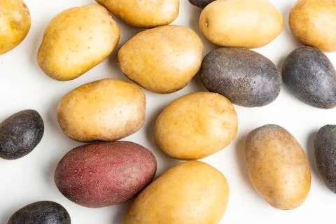 Assorted Color Potatoes On White Surface Table Stock Photos