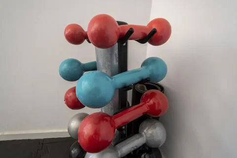 Assorted colored isolated dumbbell on stand Stock-Fotos