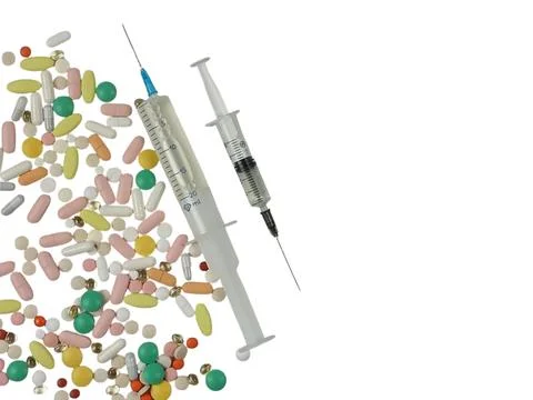 Assorted colored tablets, two syringes with medicine of different sizes. Stock Photos
