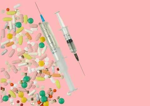 Assorted colored tablets, two syringes with medicine of different sizes. Stock Photos