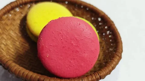 Assorted colorful French macarons inside a woven basket with copy space. Stock Footage 347487622