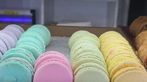 Assorted colorful macarons arranged in rows on a display tray Stock Footage 284043284
