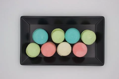 Assorted colorful macarons on black plate Stock Photos