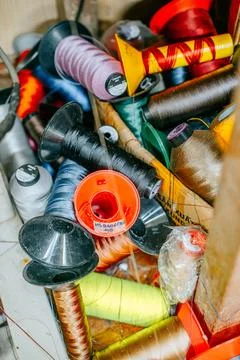 Assorted colorful sewing thread spools and cones arranged in a tailoring Stock-Fotos