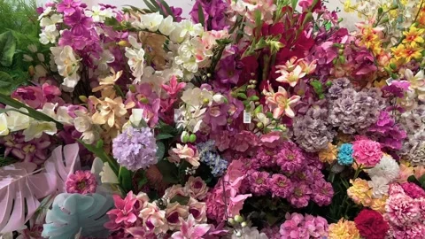 Assorted coloured artificial flowers and stems Stock Footage 240098219