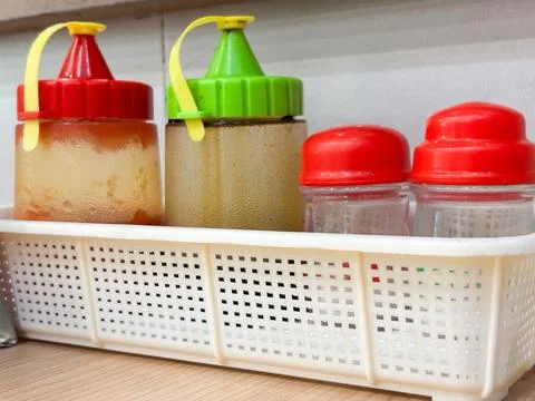 Assorted Condiments in Plastic Bottles and Shakers on a Restaurant Table Stock Photos