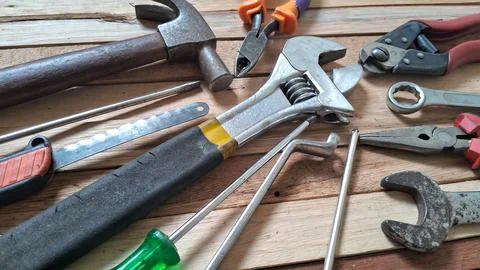 Assorted construction tools arranged neatly on a rustic wooden table surface Stock Photos