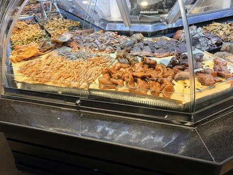 Assorted Cooked and Dried Meats Displayed in Market Showcase Fotos de archivo