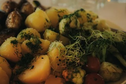 Assorted cooked vegetables including potatoes, broccoli, and cherry tomatoe.. Stock Photos