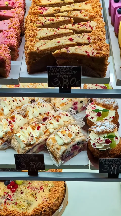 Assorted cream pastries and cakes displayed in elegant bakery showcase Stock Footage 336421383