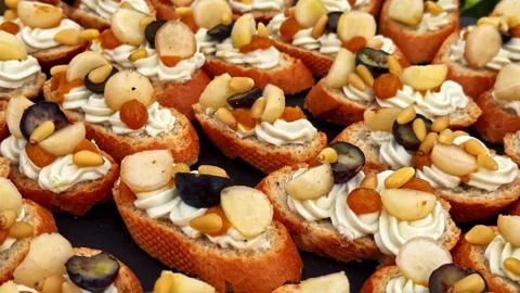 Assorted Crostini with Cheese, Fruit, and Nuts Arranged on Platter for Party Stock Footage 337386358