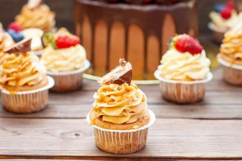 Assorted cupcakes in gift box with fresh strawberries, peanut butter, slated  Stock Photos