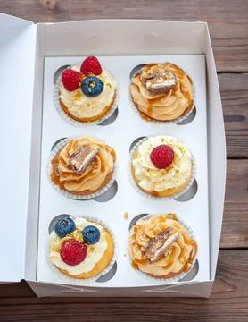 Assorted cupcakes in gift box with fresh strawberries, peanut butter, slated  Stock Photos