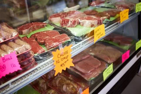 Assorted cuts of fresh meat displayed on trays Stock Photos