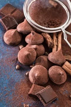 Assorted dark chocolate truffles with cocoa powder on dark blue table Stock Photos