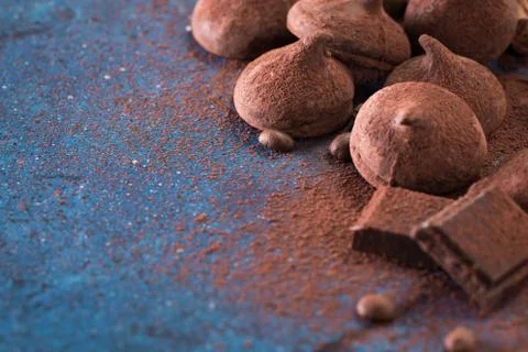 Assorted dark chocolate truffles with cocoa powder on dark blue table Stock Photos