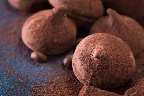 Assorted dark chocolate truffles with cocoa powder on dark blue table Foto stock