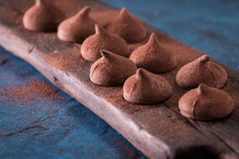 Assorted dark chocolate truffles with cocoa powder on dark blue table Stock Photos