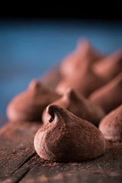 Assorted dark chocolate truffles with cocoa powder on dark blue table Stock Photos