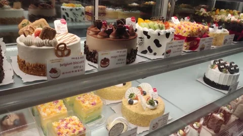 Assorted decorative cakes arranged on tray selling at bakery shop. 動画素材 295185553