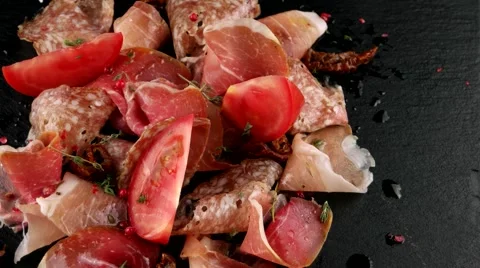 Assorted deli meats, ham, salami, bacon and tomatoes, loop Stock Footage 66481452