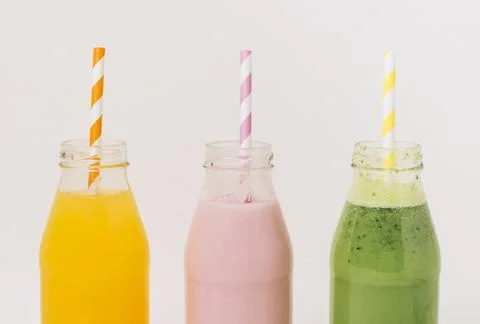Assorted delicious fruit smoothies bottles with straws. High quality photo Stock Photos