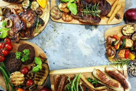 Assorted delicious grilled meat with vegetable on rustic table Stock Photos