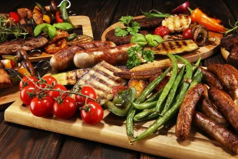 Assorted delicious grilled meat with vegetable on rustic table Stock Photos