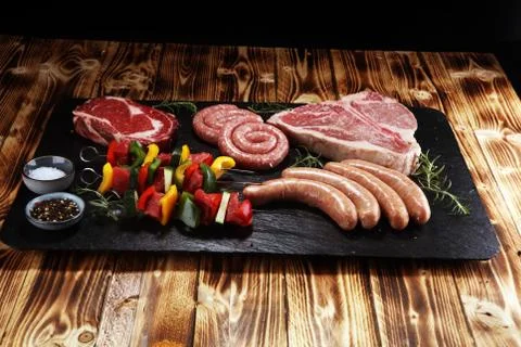 Assorted delicious raw meat with vegetable on a barbecue with t-bone steak, s Stock Photos