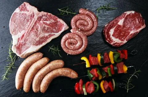 Assorted delicious raw meat with vegetable on a barbecue with t-bone steak, s Stock Photos