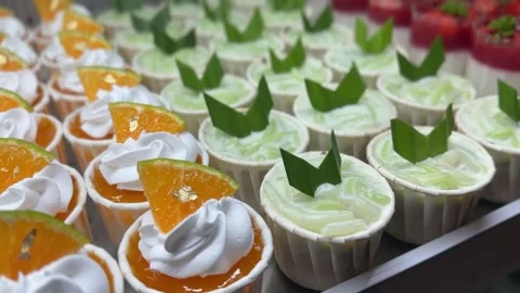 Assorted desserts of orange cupcakes, tapioca starch jelly in coconut milk Video stock 314708216