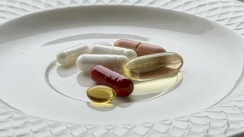 Assorted dietary supplements on plate Stock Photos
