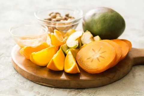 Assorted different fruits: persimmon, apple, oranges Stock Photos