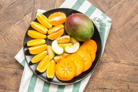 Assorted different fruits: persimmon, apple, oranges Stock Photos