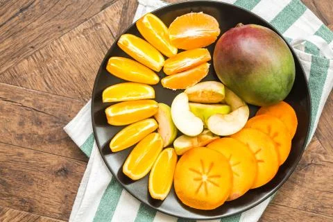 Assorted different fruits: persimmon, apple, oranges Stock Photos