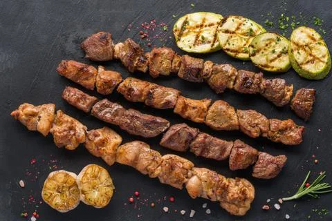Assorted different kebabs on a black stone plate Stock Photos