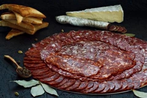 Assorted different types of cheese sausage on a dark background. Stock Photos