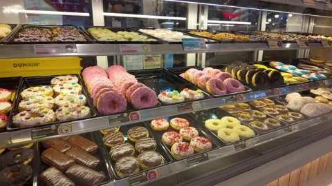 Assorted donuts and pastries displayed in glass bakery counter 動画素材 318124900
