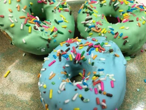 Assorted donuts with chocolate frosted, pink glazed and sprinkles donuts. Stock Photos